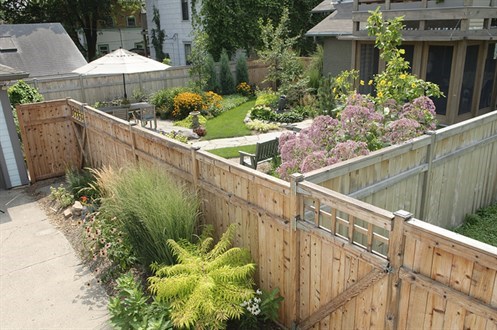 Fencing surrounding well kept gardens with flowers