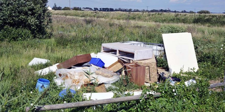 Household rubbish abandoned in field by flytippers