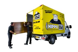 Two men loading a warddrobe into a HIPPO van