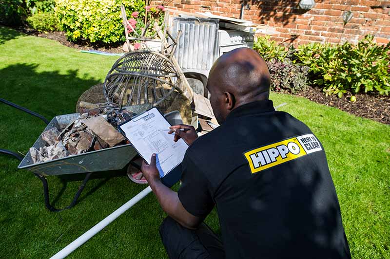 Man and van team member assessing and checking rubbish to be removed