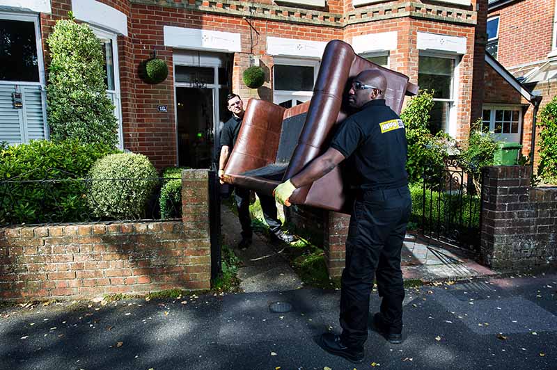 Man and van team removing a sofa from a house