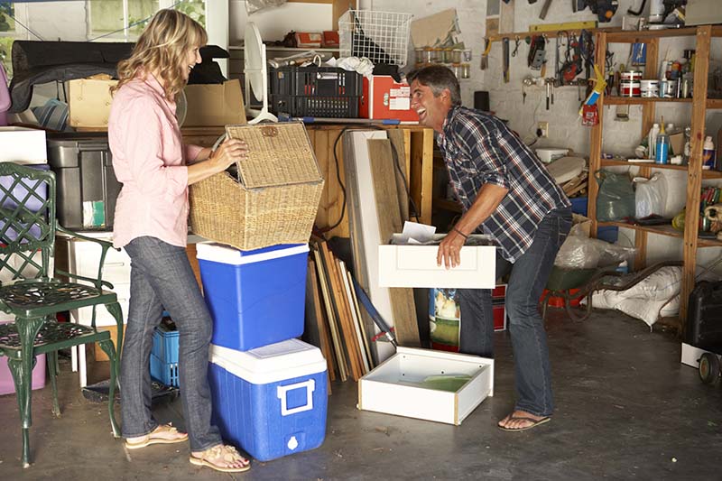 A couple clearing rubbish in a garage