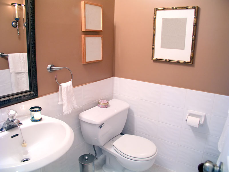A newly redecorated WC room with paint and white tiles on the lower half of the room
