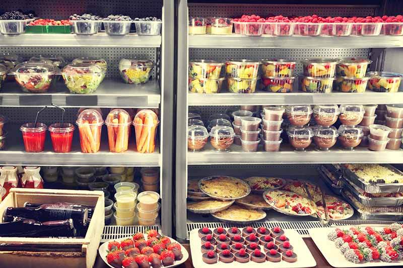 Supermarket fridge section filled with food in plastic packaging