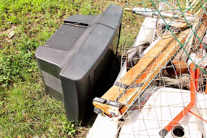 Old TV placed with other waste ready for collection