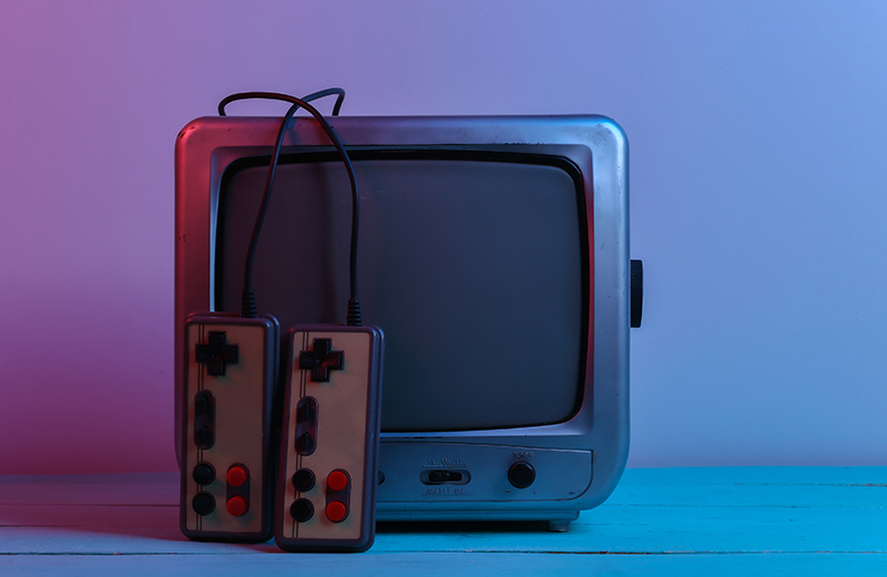 An old TV with retro games console controllers