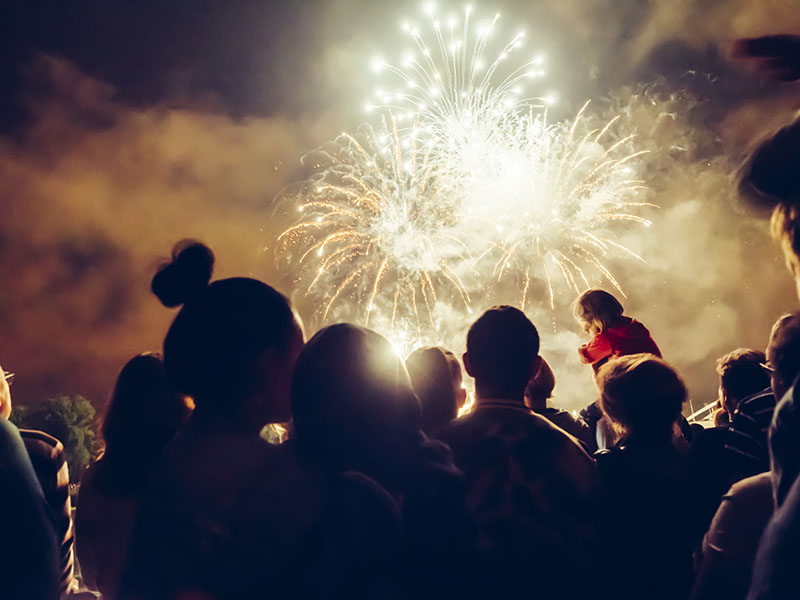 A large crowd of people watching fireworks