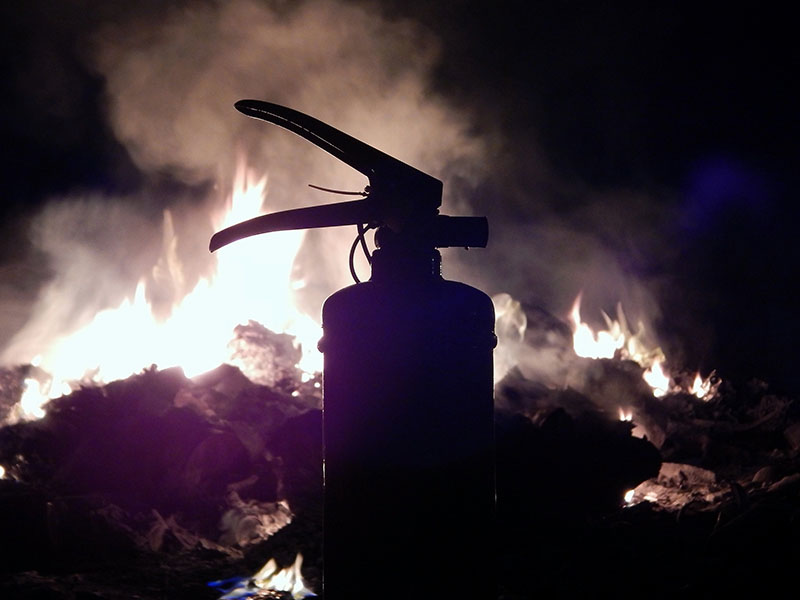 A fire extinguisher placed near a bonfire