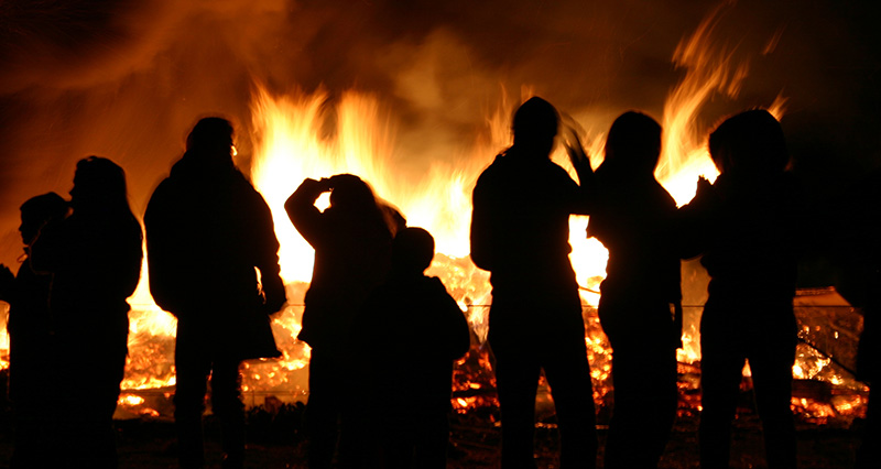 A group of people stood near a bonfire