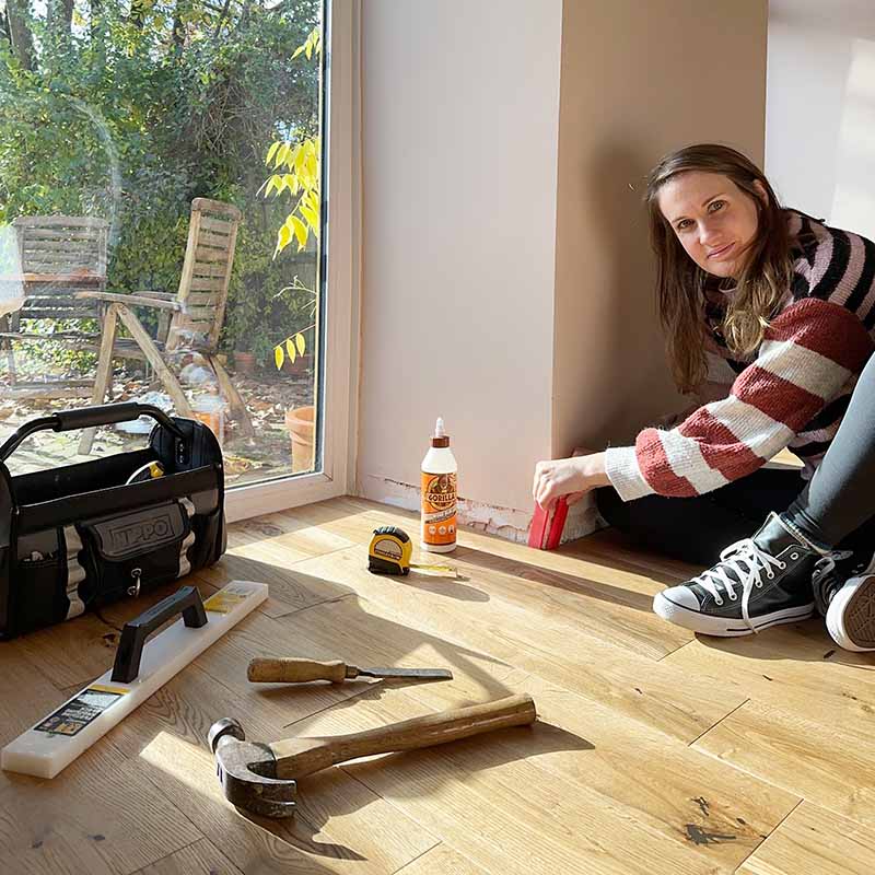 Woman laying wooden floor for DIY Project