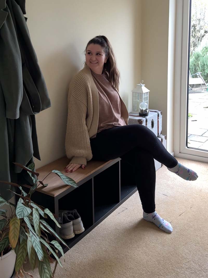 Woman sitting on a shoe storage bench in a hallway