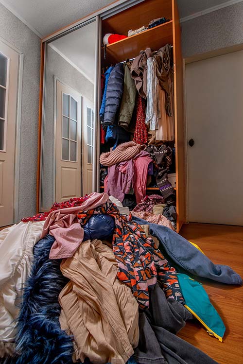 Pile of clothes on floor by wardrobe ready for recycling