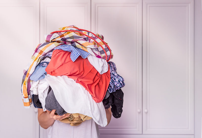 Person holding a pile of clothes