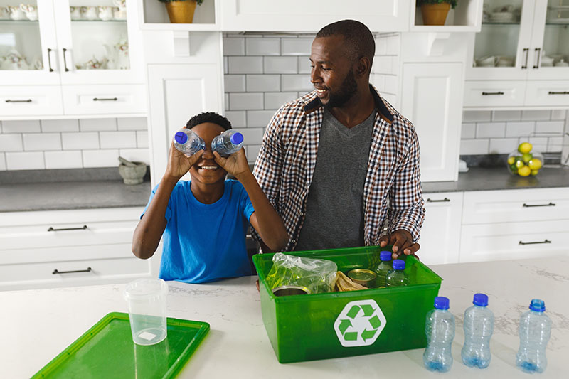 A father and son sorting recycling in a kitchen