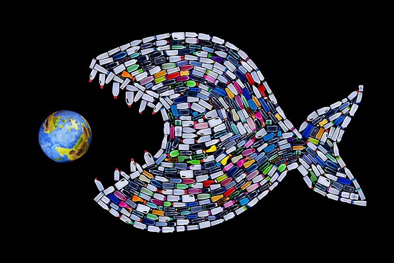 A fish made of plastic bottles eating planet Earth