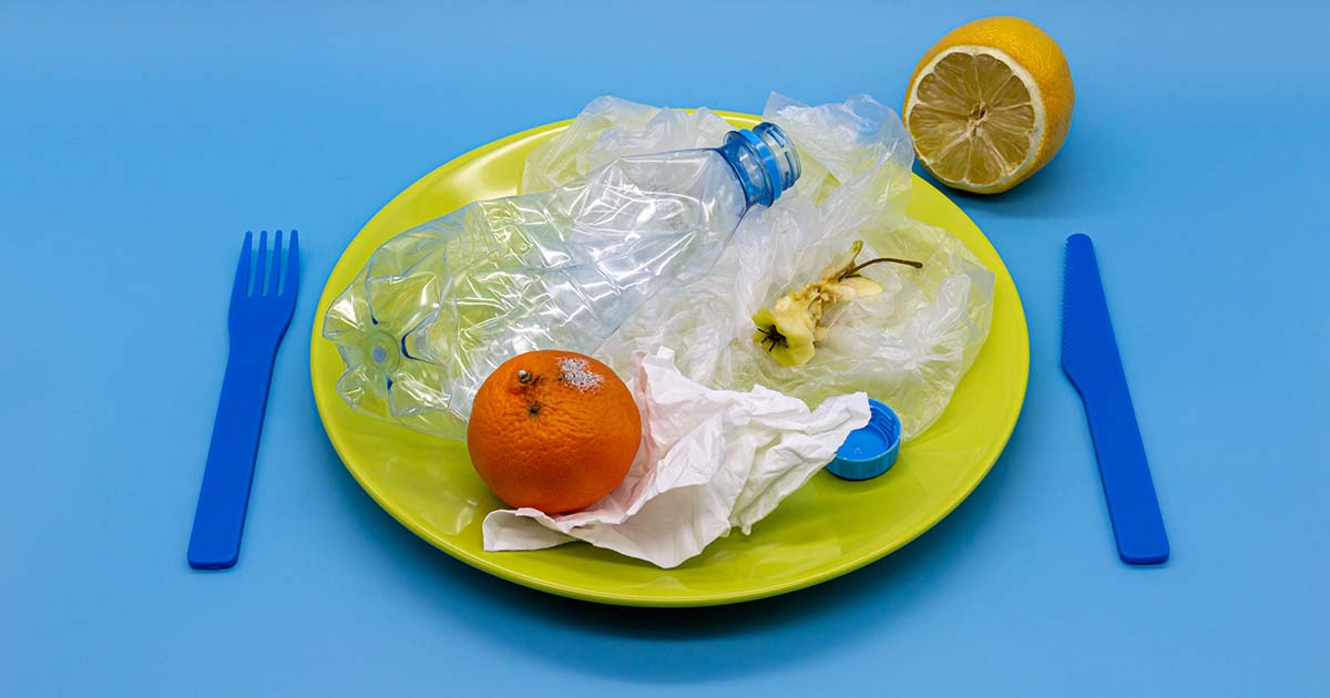 A plastic plate and fork with mixed waste for recycling