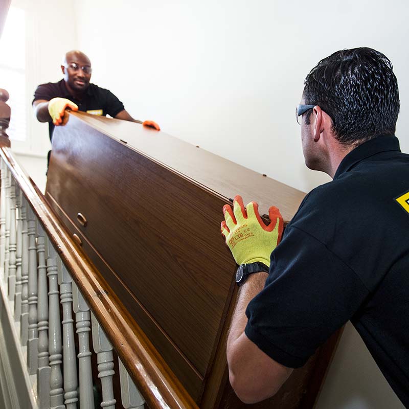 HIPPO Man & Van moving a wardrobe down a stairs for disposal