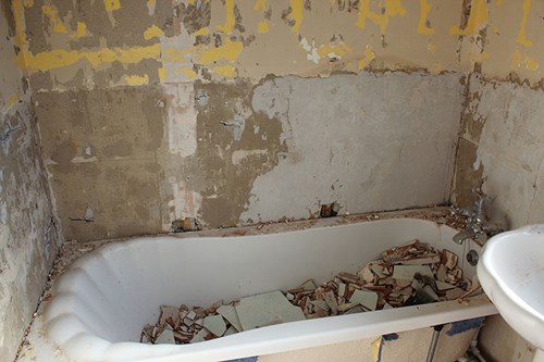 Bathtub filled with broken tiles from bathroom renovation
