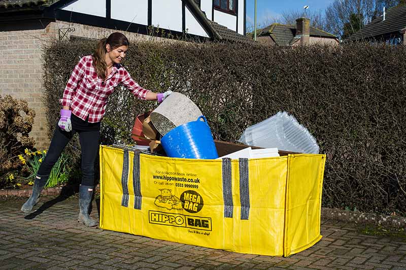 A woman filling our medium HIPPOBAG, a MEGABAG, on a driveway